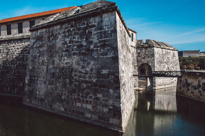 Old bridge over river against buildings