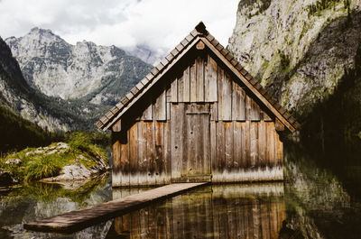 Log cabin in lake against mountains