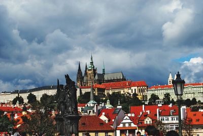 View of buildings in city against cloudy sky