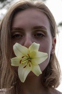 Close-up portrait of woman carrying flower in mouth