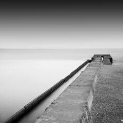 Pier by sea against sky during foggy weather