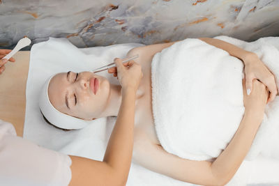 Close-up portrait of woman getting spa facial massage treatment