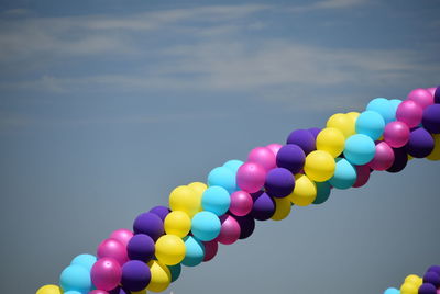 Low angle view of balloons flying against sky