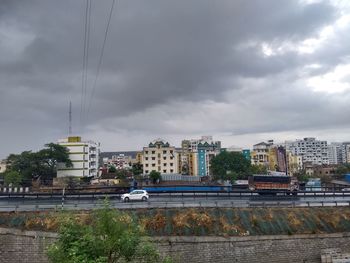 View of cityscape against cloudy sky