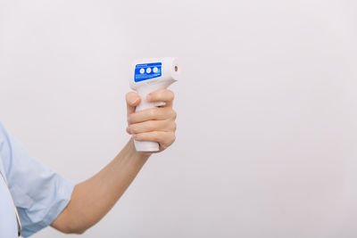 Close-up of hand holding paper against white background