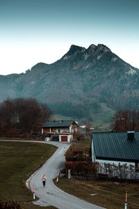 Scenic view of road by mountains against sky