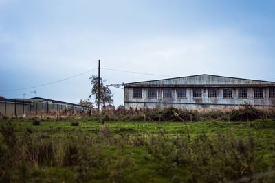 Abandoned building on field against sky