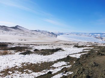 Scenic view of snowcapped mountains against blue sky