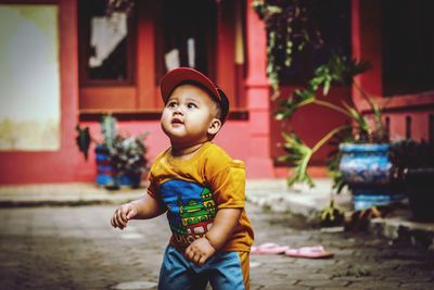 Cute boy looking away while standing outdoors