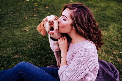 Young woman with dog sitting outdoors