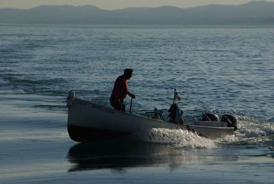 Men in boat on sea against sky