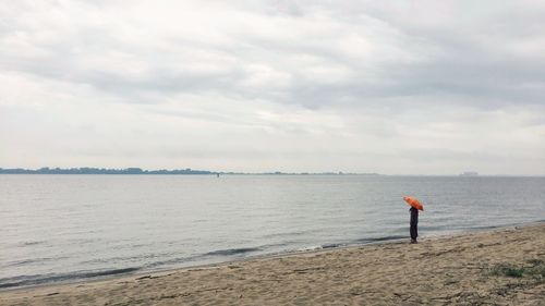 Man standing on beach against sky