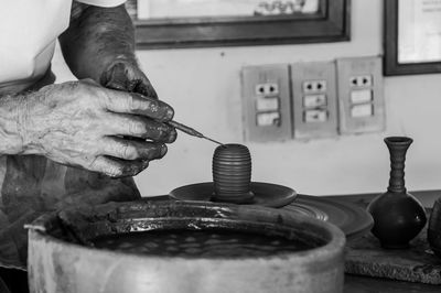 Midsection of man preparing clay craft product