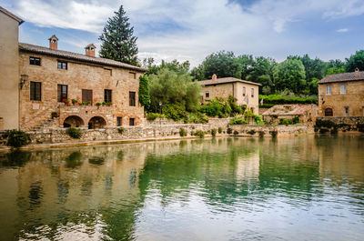 Building by river against sky