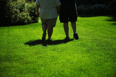 Low section of people walking on grassland