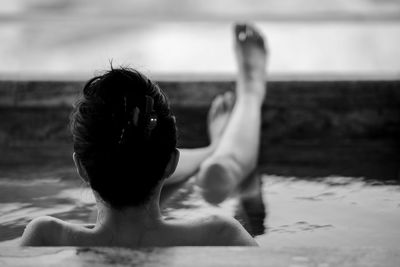 Side view of young woman sitting at beach