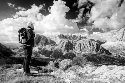 Side view of backpack man hiking on mountains against cloudy sky