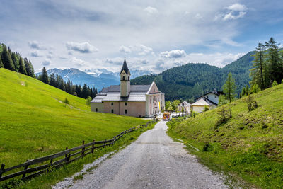 Scenic view of building by mountains against sky