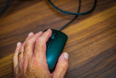 Man left hand on computer mouce on desk