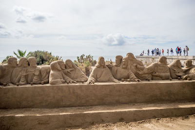 Statues on landscape against sky