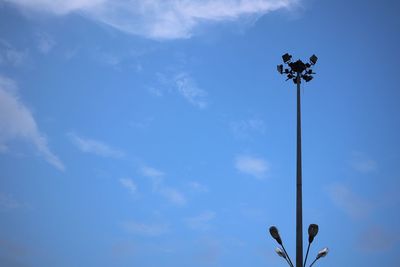 Low angle view of street light against blue sky