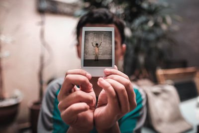 Man holding instant print transfer at home