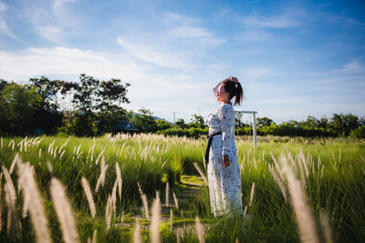 Woman standing on field against sky