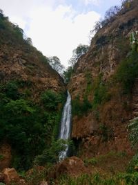 Scenic view of waterfall against sky