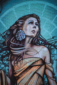 Portrait of young woman against wall