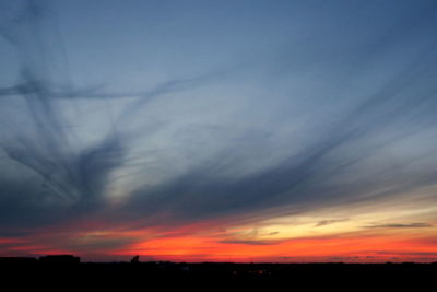 Scenic view of silhouette field against dramatic sky