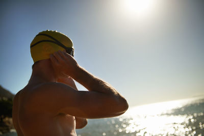 Low angle view of young man with arms raised