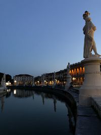 Statue of illuminated building against sky at dusk