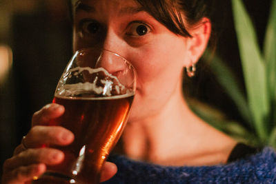 Portrait of woman drinking beer