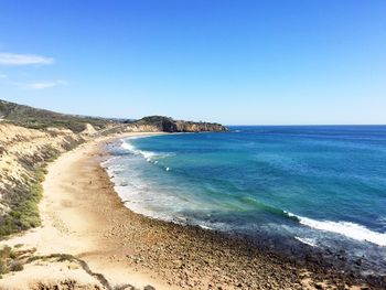 Scenic view of beach against blue sky