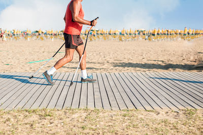 Man with poles running on boardwalk