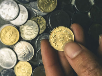 Close-up of hand holding coin