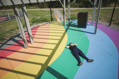 Young woman lying on colorful ground