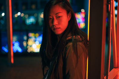 Portrait of young woman looking away at night