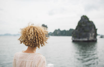 Rear view of woman looking at sea against sky