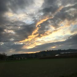 Scenic view of dramatic sky over land during sunset