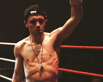 Shirtless man standing at boxing ring