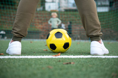 A little boy plays soccer with his father on the soccer field