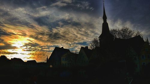 Low angle view of buildings against cloudy sky