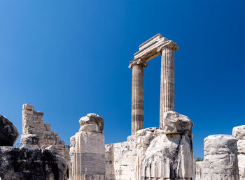 Low angle view of old ruins against clear blue sky