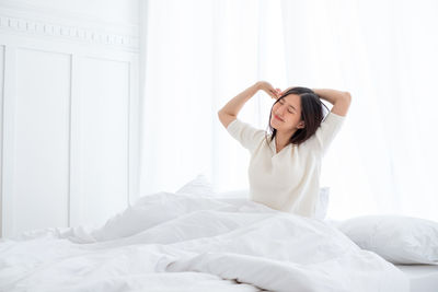 Young woman lying on bed at home