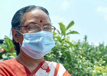 Portrait of an aged indian woman wearing surgical face mask due to covid-19 pandemic.