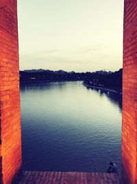 Reflection of built structure in water against clear sky