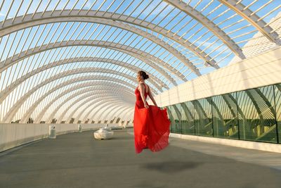 Full length rear view of woman standing on footbridge