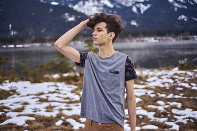 Young man standing in lake during winter