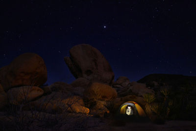 Low angle view of illuminated rocks against sky at night